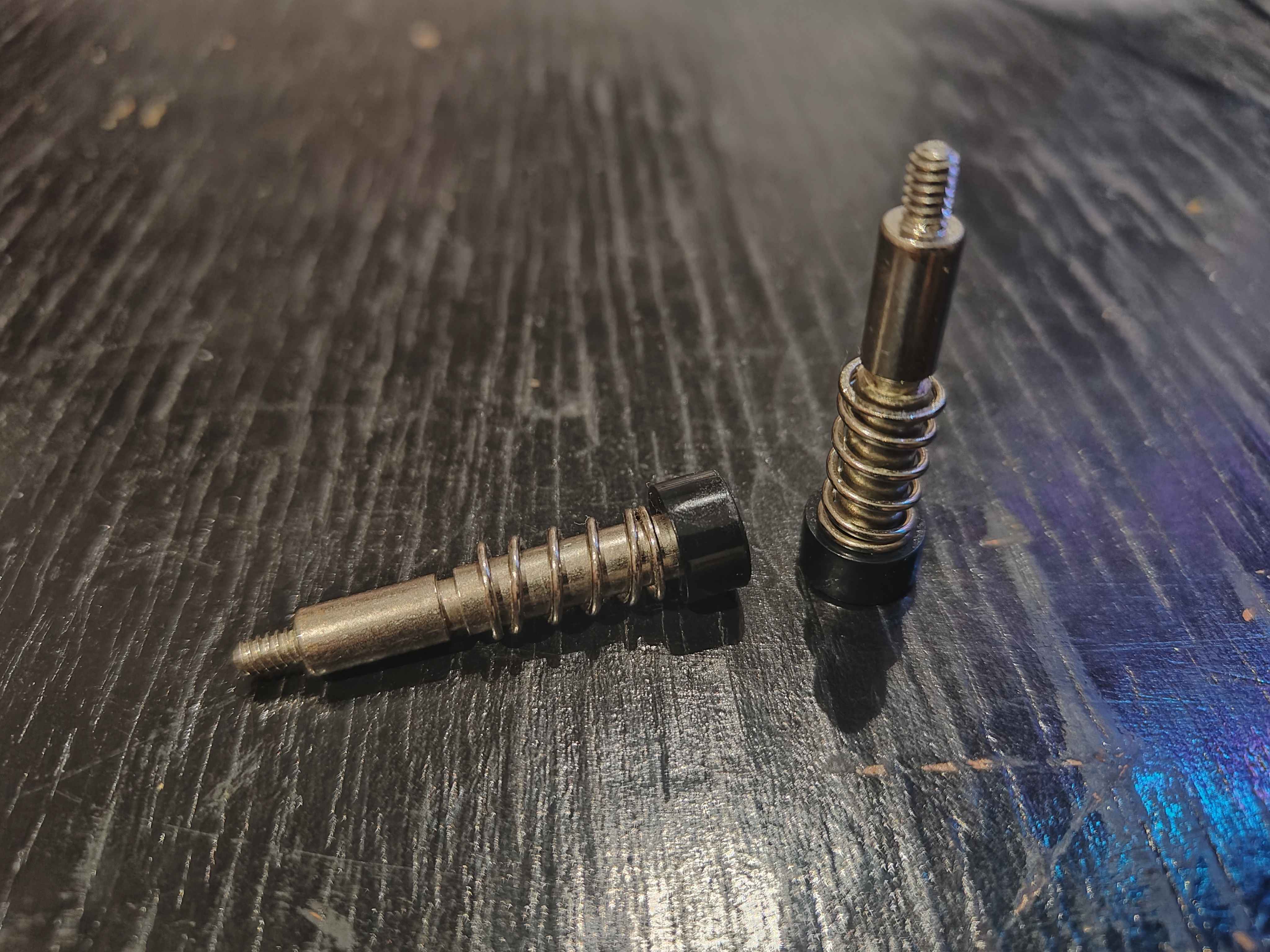 Two screws of HP Compaq 8100 CPU cooler, one standing, the other tipped over